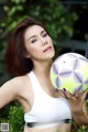 A woman holding a soccer ball in her hands.