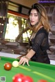 A woman is playing a game of pool. 