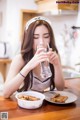 A woman sitting at a table with a glass of water.