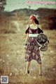 A woman walking through a field holding a basket.