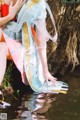 A woman in a colorful dress is sitting in the water.