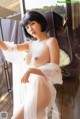 A naked asian woman posing in a white dress.