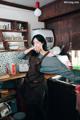 A woman in an apron standing in a kitchen.